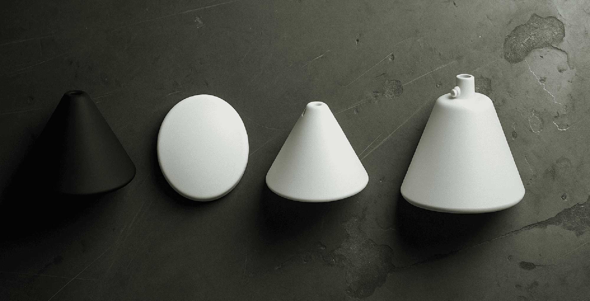 Fyra olika takbrickor och takstycken i vitt och svart, centrerade mot en mörk industriell bakgrund – visar variationer i form, färg och infästning.